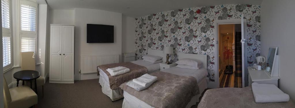 吉尔福德相思别墅旅馆的酒店客房设有两张床和电视。