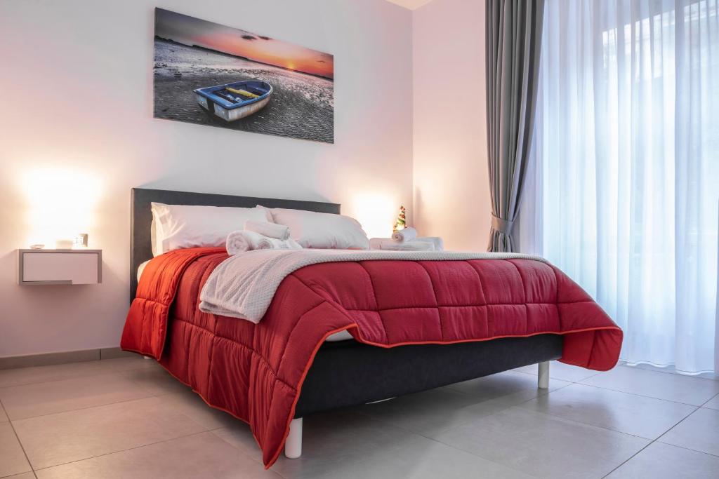 那不勒斯La Casina Rossa的一间卧室配有一张带红色毯子的床