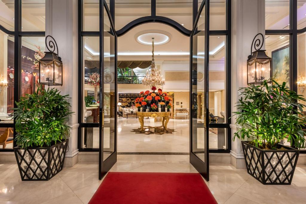 洛杉矶Beverly Hills Plaza Hotel & Spa的大堂有两株盆栽植物和红色地毯