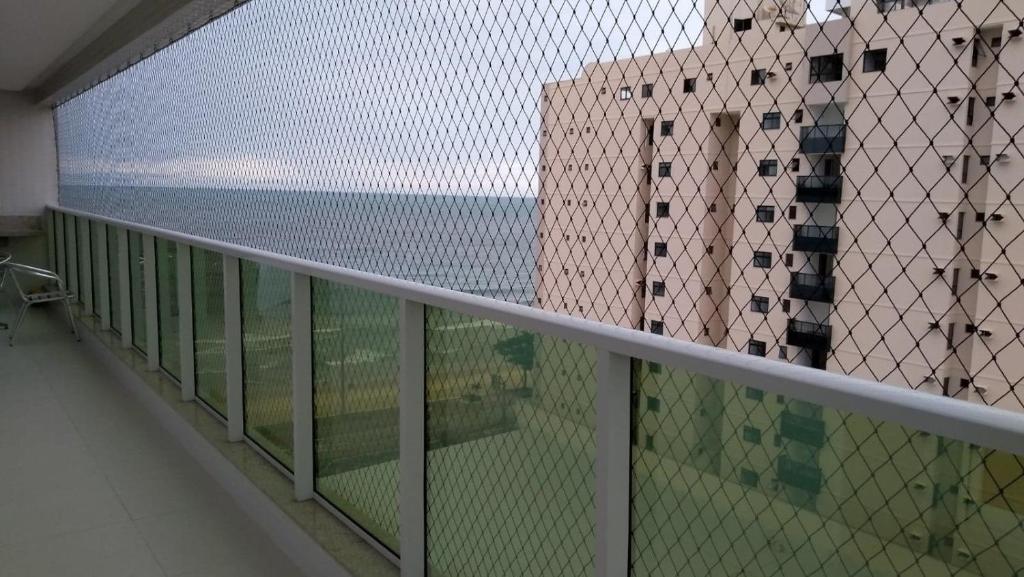 瓜拉派瑞apartamento praia do morro - beira mar的阳台享有大海和建筑的景致。
