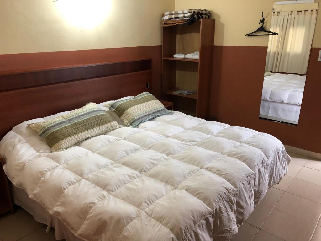 科连特斯Hospedaje San Lorenzo的一张大白色的床,位于带镜子的房间里
