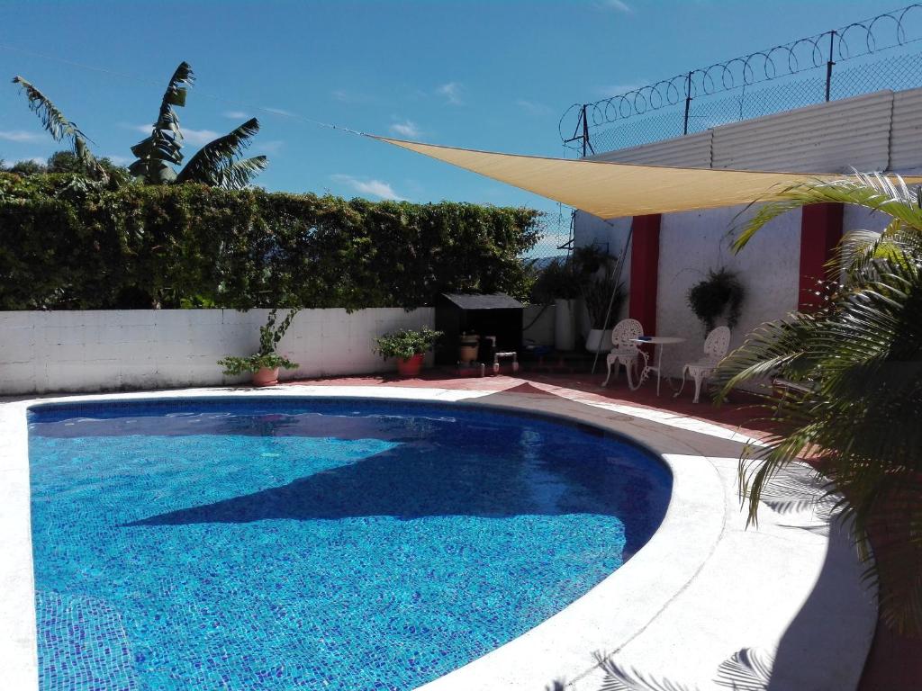 圣萨尔瓦多Casa San Benito的一座大型蓝色游泳池,位于房子旁边