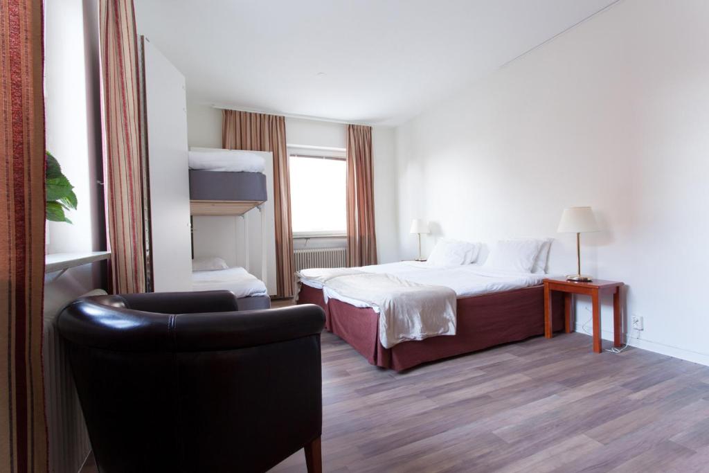 诺尔雪平Hotell Drott的配有一张床和一把椅子的酒店客房