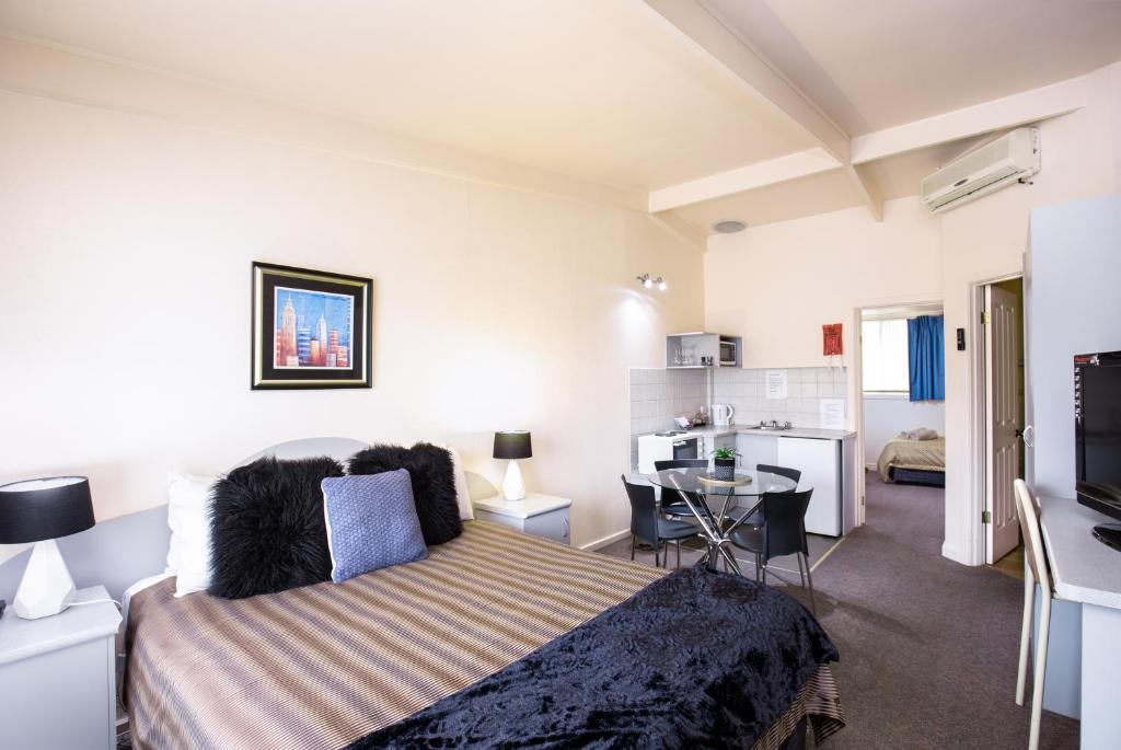 芒特甘比尔Mid City Motel的一间卧室配有一张床和一个小厨房