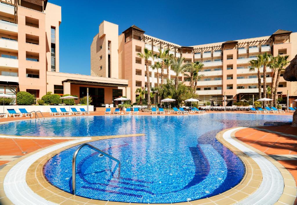 萨洛H10萨拉乌里斯皇宫酒店的一座带蓝色椅子的大型游泳池,