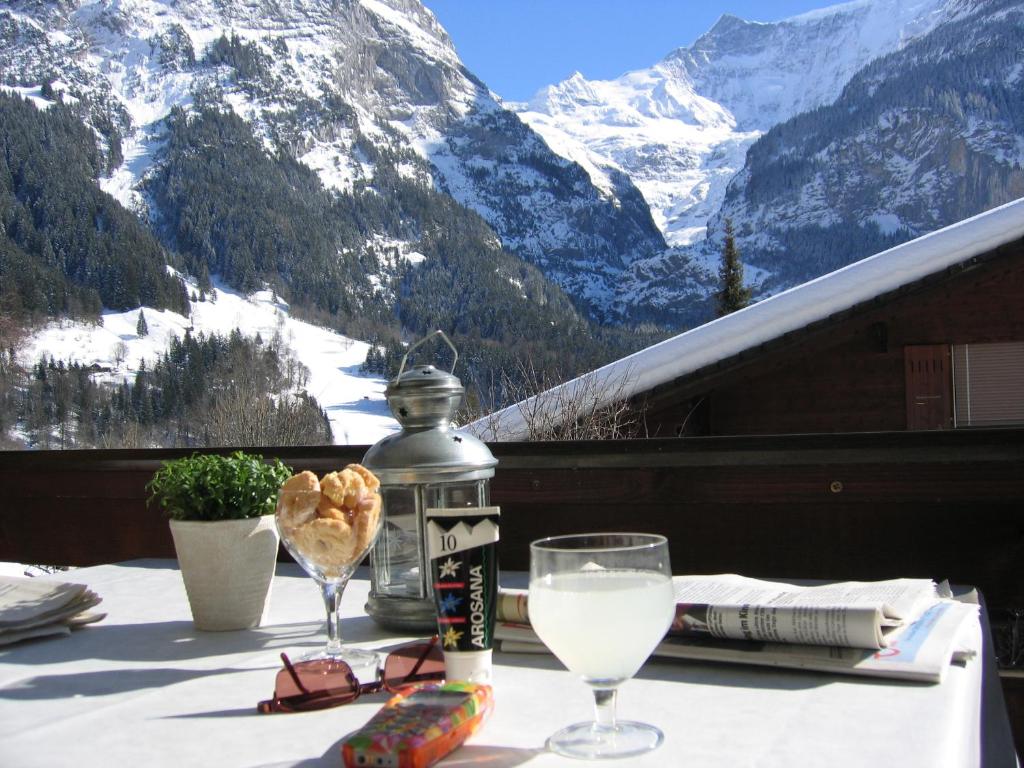 格林德尔瓦尔德Casa Almis, Grindelwald的一张桌子,上面放着一杯葡萄酒,享有山景