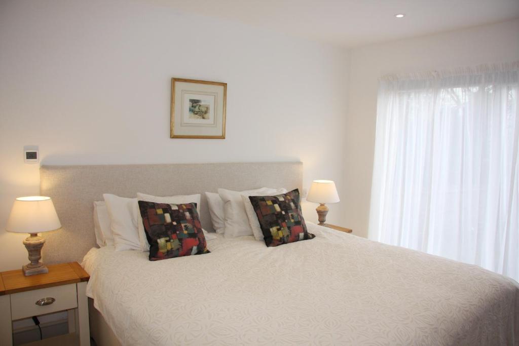 刘易斯Marshlands Apartment的卧室配有带枕头的白色床和窗户。