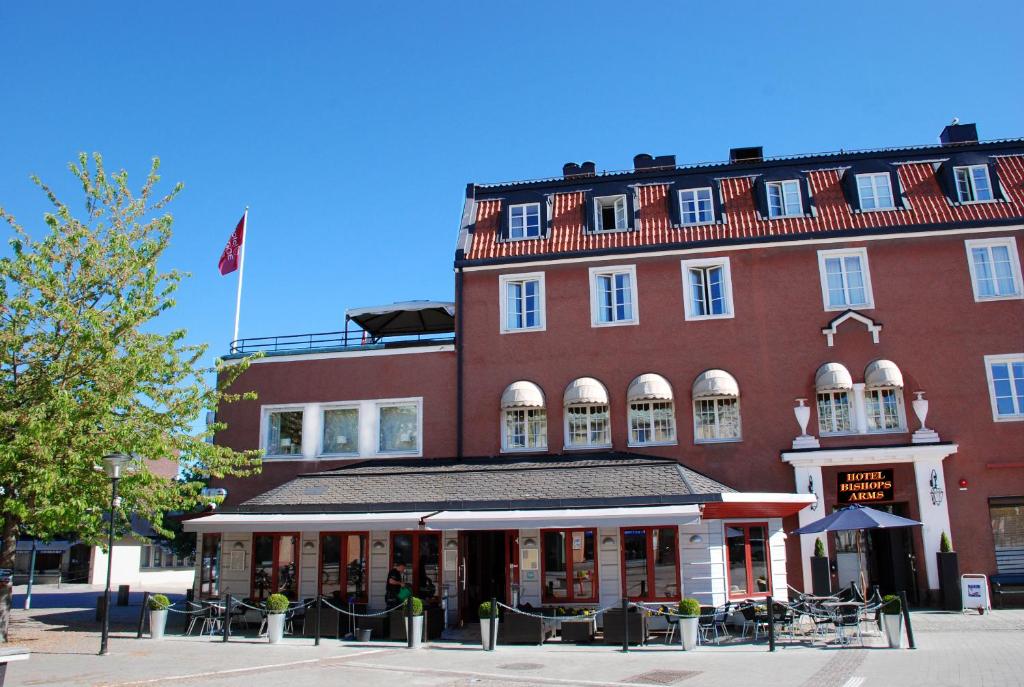斯特兰奈斯Hotel Bishops Arms Strängnäs的一座大红砖建筑,上面有旗帜