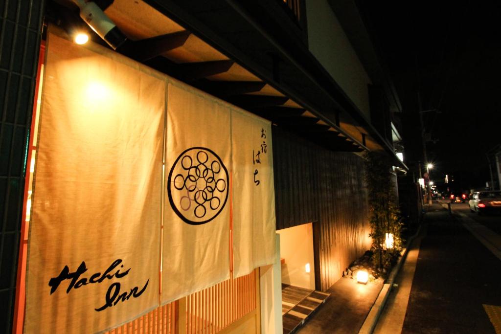 京都Hachi Inn的夜间建筑物一侧的标志