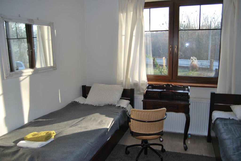 斯特雷库夫Pokoje nad Młynem的一间卧室配有一张床、一张桌子和一把椅子