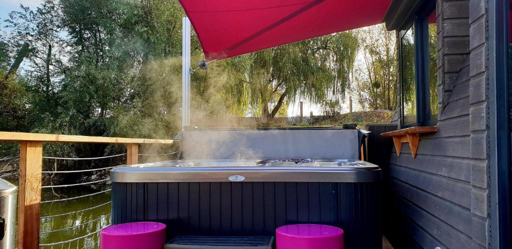 沙布利Lodges des grands crus的红伞下带粉红色凳子的热水浴池