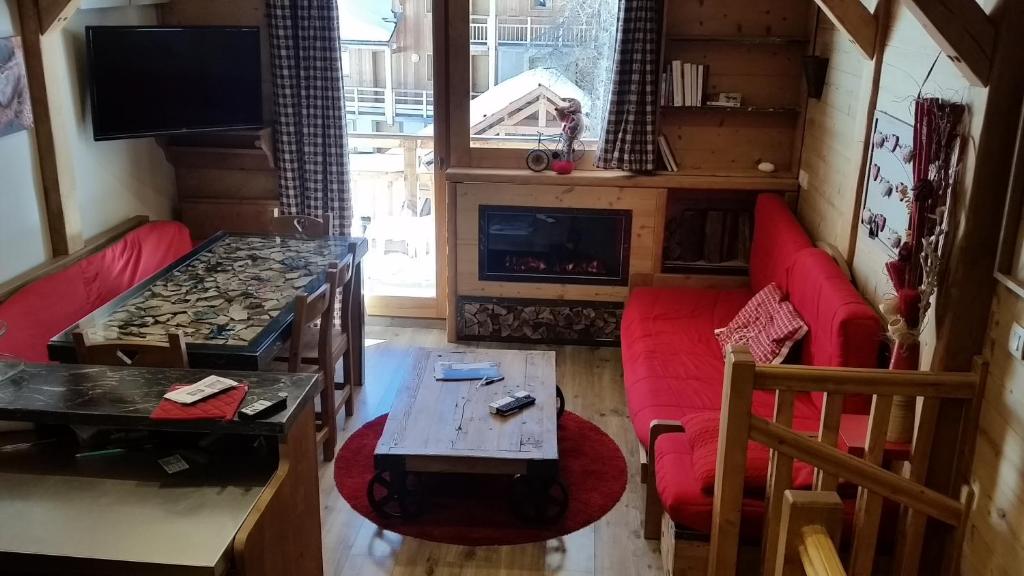 瓦尔chalet des rennes的客厅设有红色的沙发和壁炉