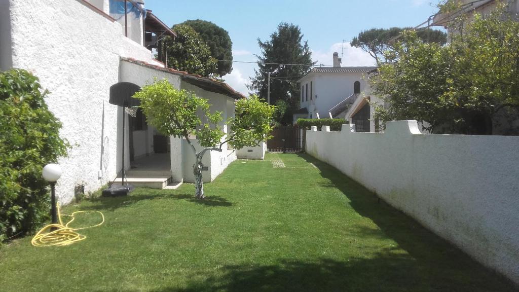 圣费利切-奇尔切奥Villa Colle Circeo 1°的绿草成荫的院子和白色的墙壁