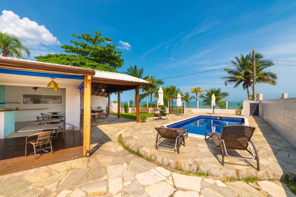 卡拉瓜塔图巴佩黑沙娜望厦宾馆的一个带椅子的庭院和一个游泳池