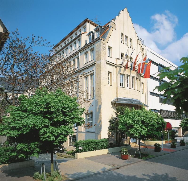 科隆维克托亚酒店的一座白色的大建筑,上面有旗帜