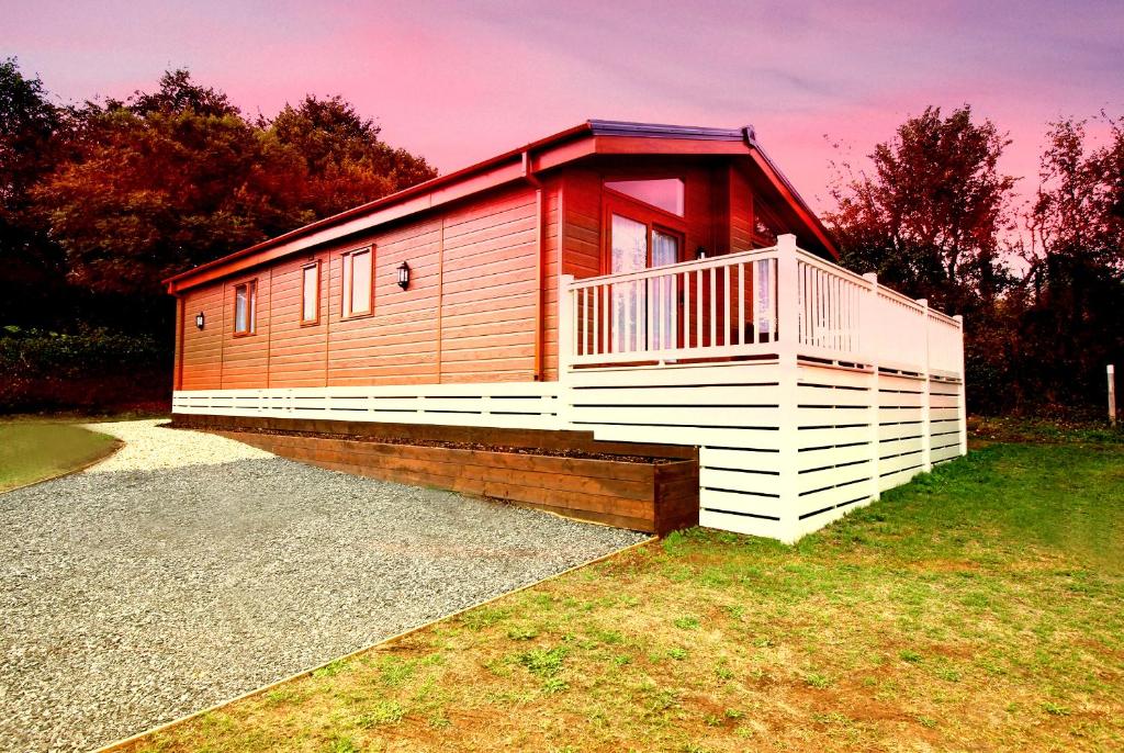 切达Bucklegrove Holiday Park的小屋设有红色和白色的甲板