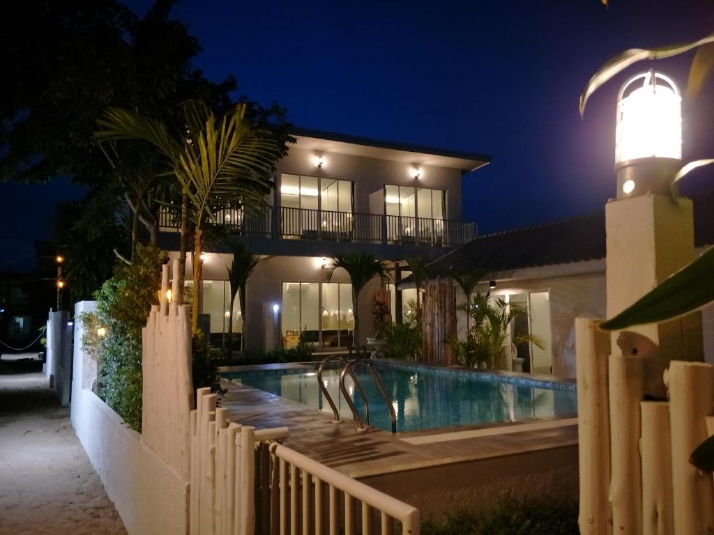科隆万Sea Sand House Resort的一座带游泳池的房子和一座灯塔