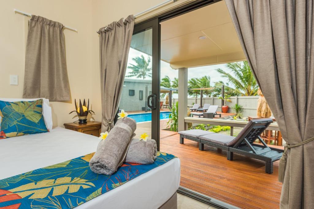 穆里Cook Islands Holiday Villas - Turangi Lagoon的一间卧室设有一张床和一个阳台