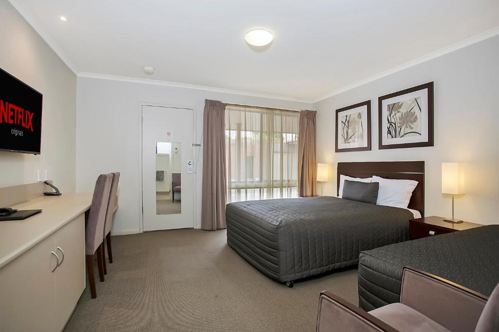 沃纳姆堡榆树汽车旅馆的配有一张床和一张书桌的酒店客房