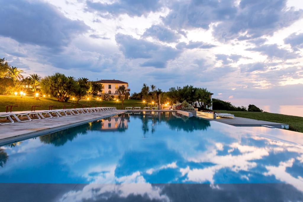 圣让-德吕兹储备酒店的一个带椅子的游泳池和一个背景建筑