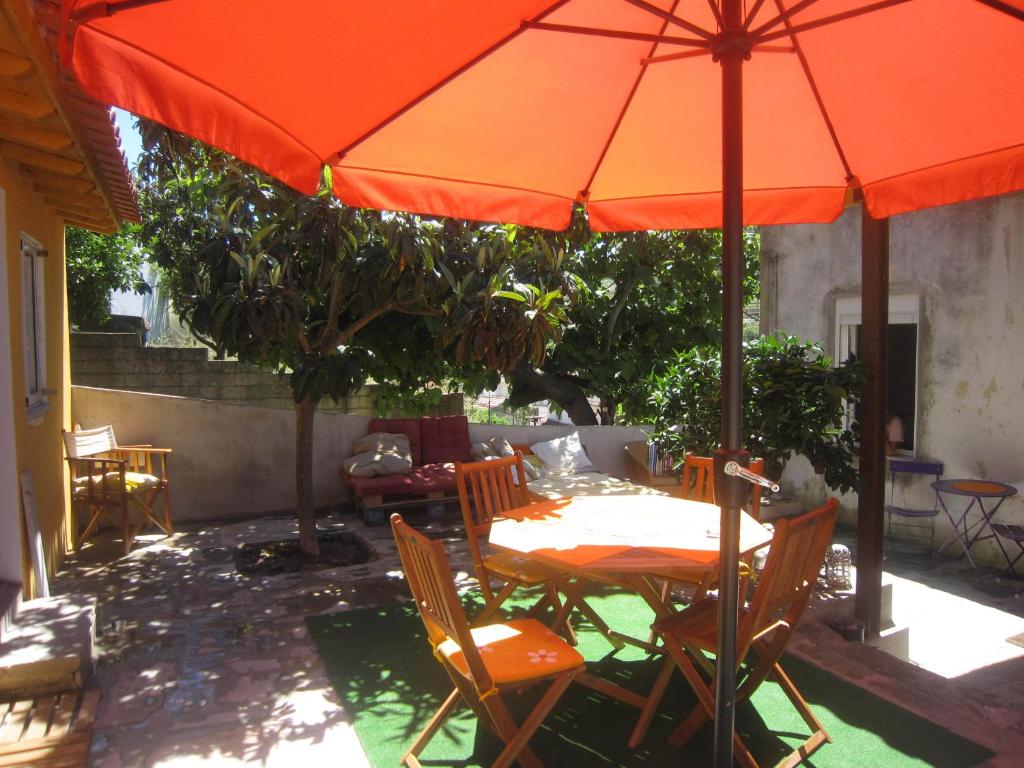 皮尼昂Casas Botelho Elias的庭院里配有带橙色遮阳伞的桌子