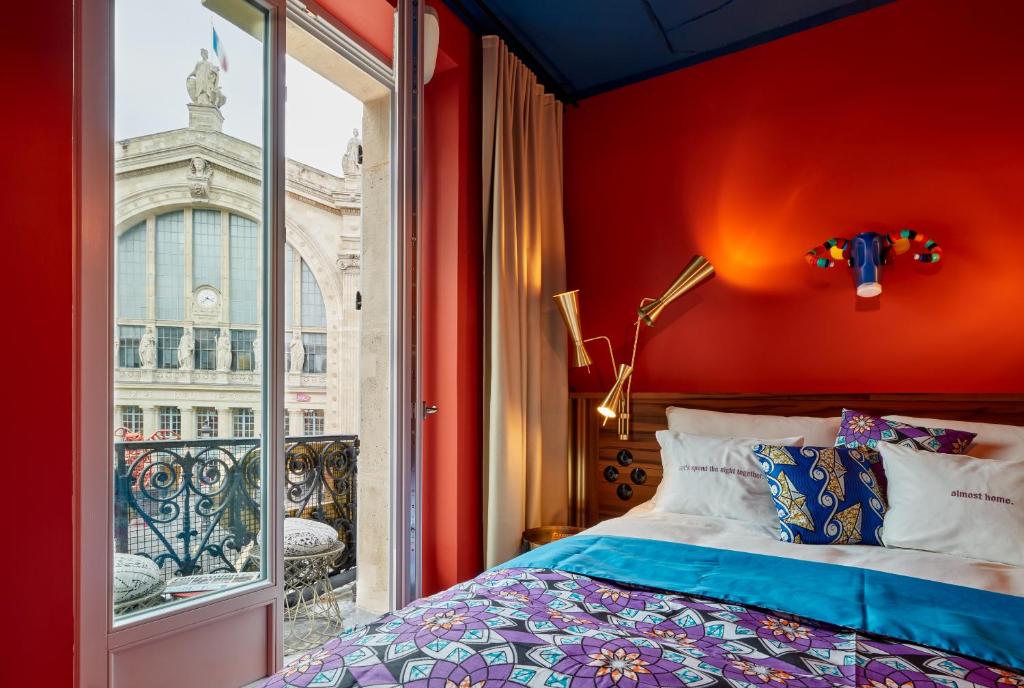 巴黎25hours Hotel Terminus Nord的卧室设有红色的墙壁和窗户。