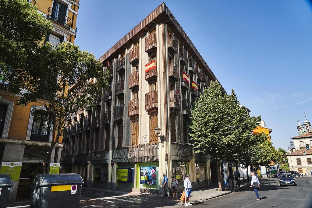 马德里Apartamentos Cava Baja的街上的一座建筑,前面的人在街上行走