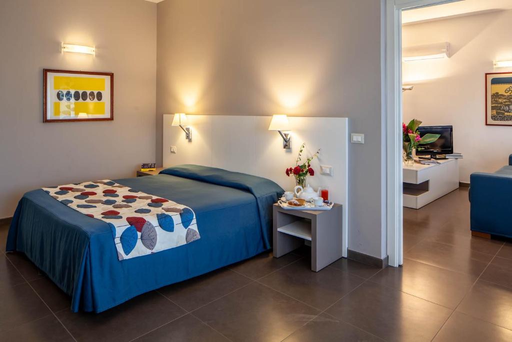 巴勒莫玛尔贝拉公寓式酒店的一间卧室配有一张床、一张桌子和一台电视