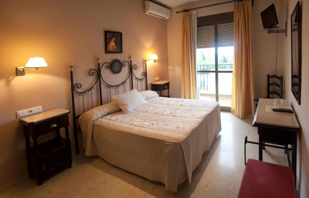 阿尔莫多瓦尔德尔里奥圣路易斯旅馆的一间卧室设有一张大床和一个窗户。