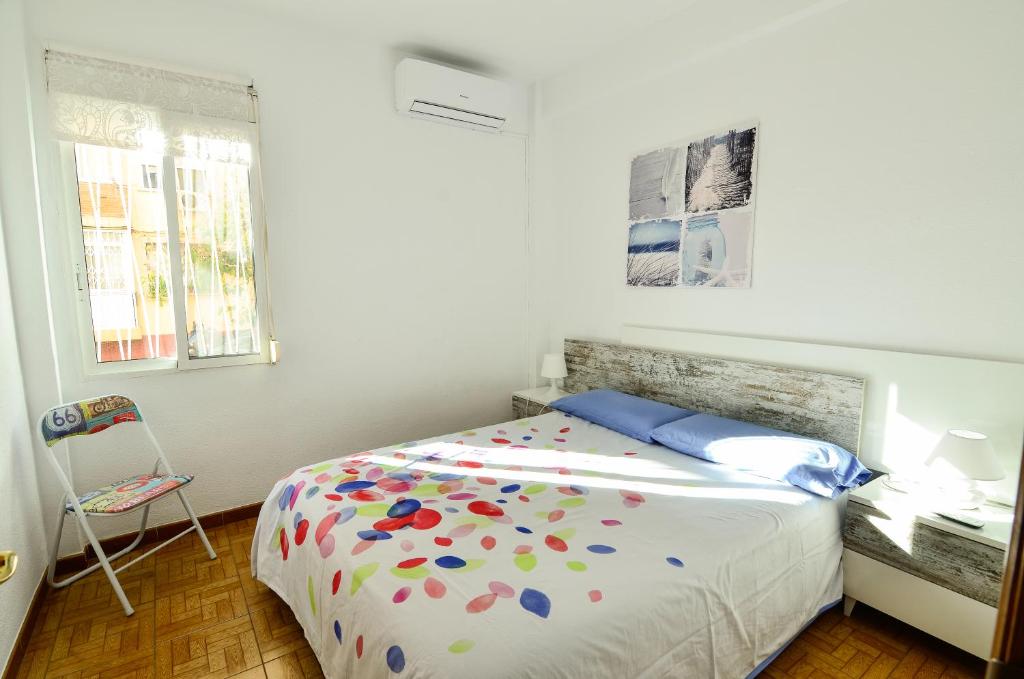 瓦伦西亚Disfruta De Playa Y Ciudad的一间卧室配有一张床、一张书桌和一个窗户。