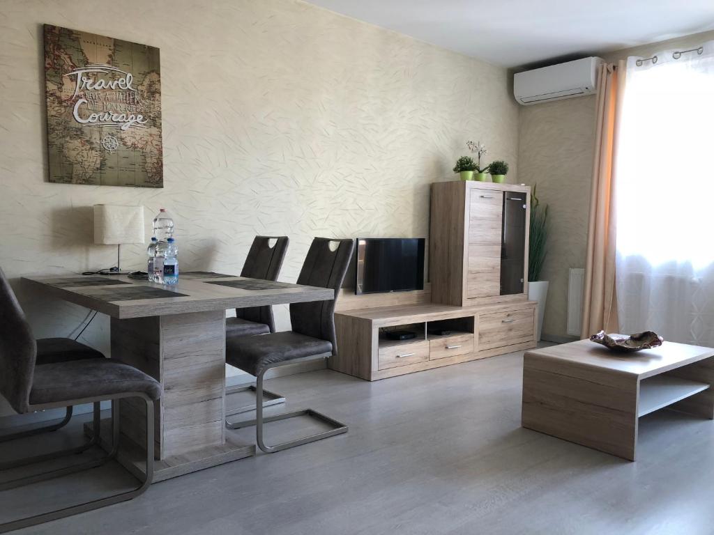 布达佩斯Aden Apartment free parking的客厅配有桌椅和电视。
