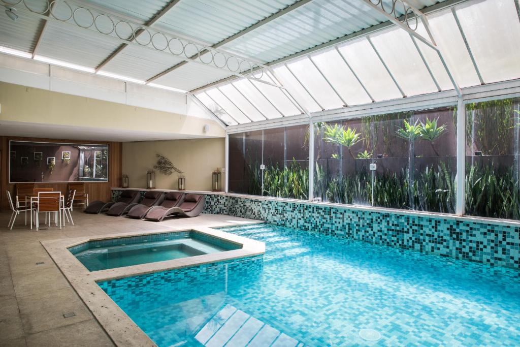 圣保罗Hotel Heritage的一座带大窗户的房屋内的游泳池