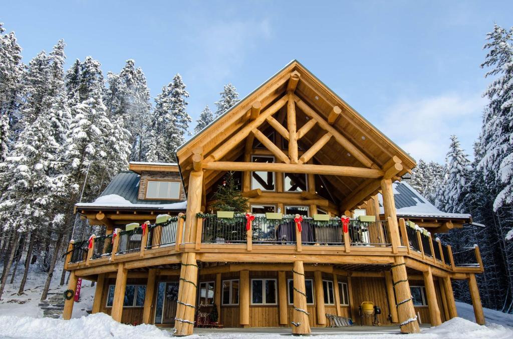 戈尔登Golden Acres Mountain Lodge的雪地里的木屋,阳台上的人
