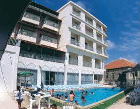 布罗马纳克里隆酒店的一座大型建筑,前面设有一个游泳池
