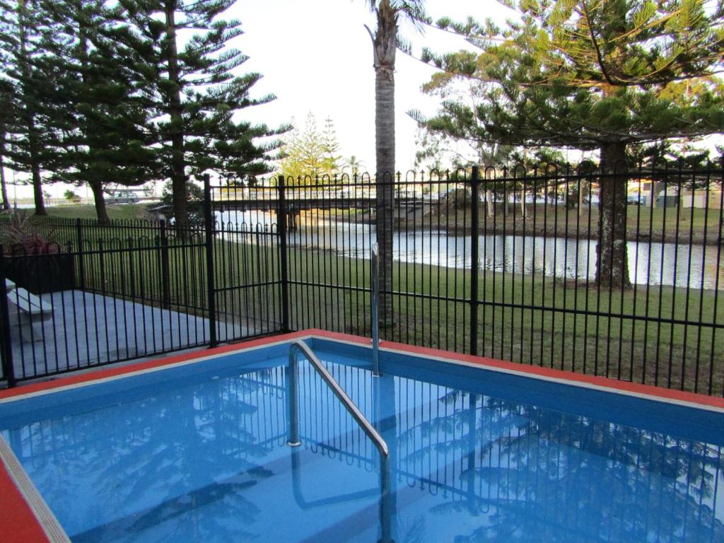 麦夸里港乔治汽车旅馆的一座带金属围栏和树木的游泳池