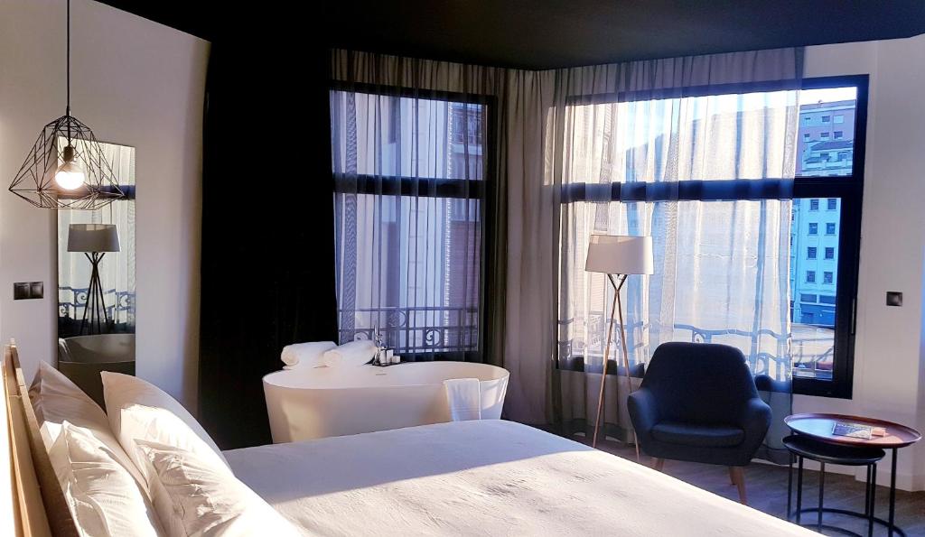 毕尔巴鄂Hotel Tayko Bilbao的一间卧室配有一张床、一张书桌和一个窗户。