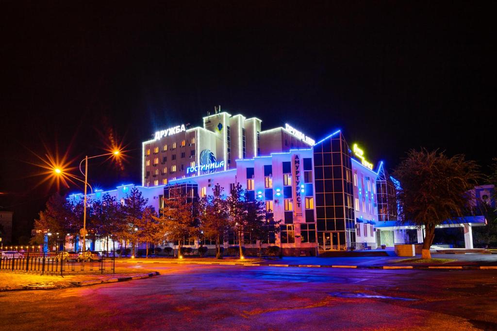 布拉戈维申斯克德鲁日巴酒店的一座晚上有蓝色灯光的建筑