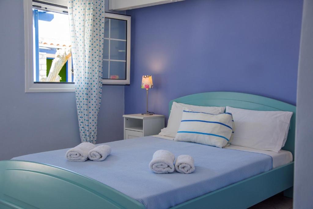 凯瑟拉Vikentios Rooms的蓝色卧室,配有带毛巾的床