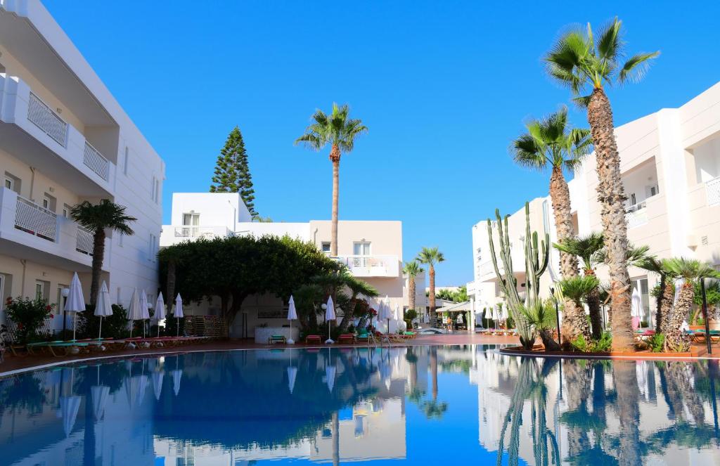 古瓦伊Magda Hotel Club的一座棕榈树和建筑的大型游泳池