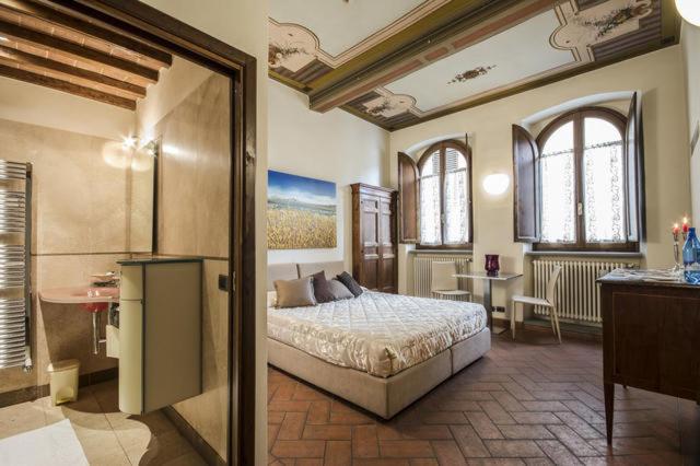 阿雷佐拉寇特德尔里酒店的一间设有床铺的卧室,位于带窗户的房间内