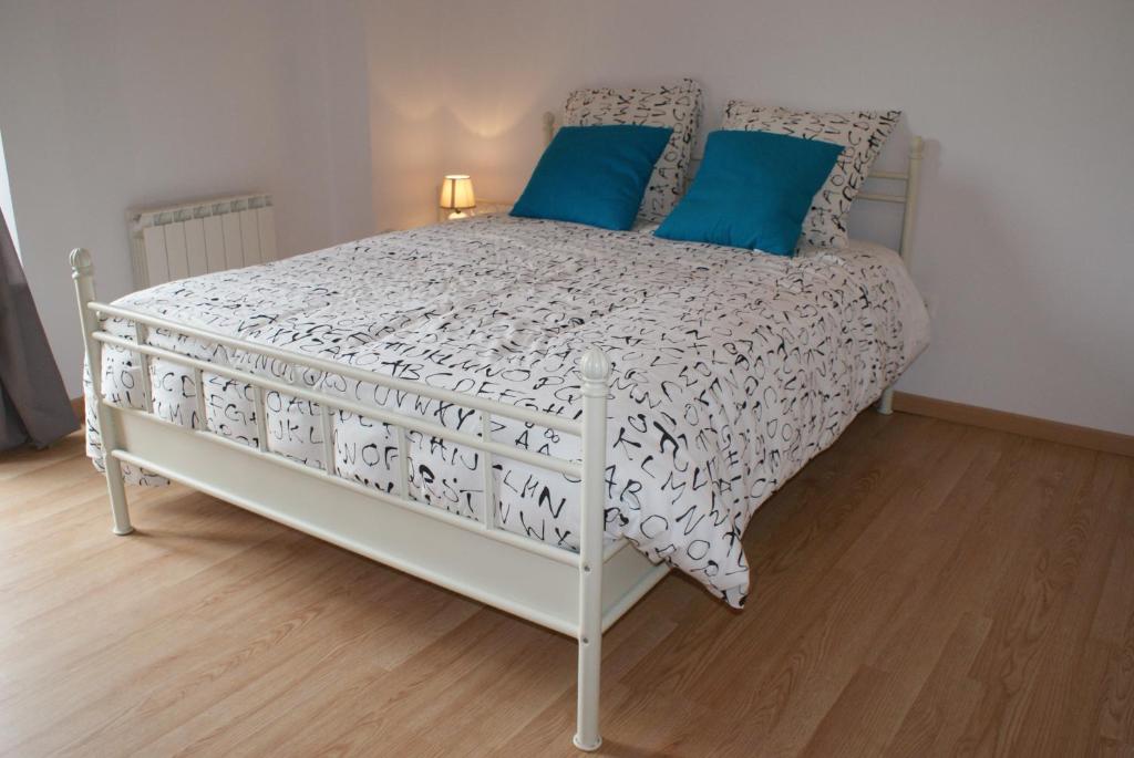Crézilles克莉斯勒斯酒店的卧室内的白色床和蓝色枕头