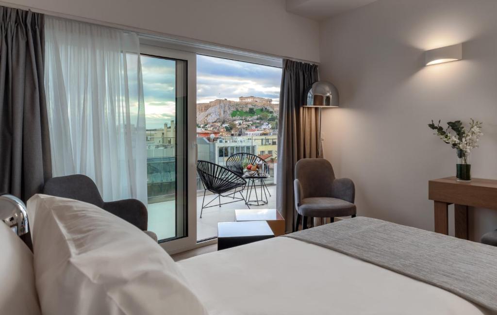 雅典Elia Ermou Athens Hotel的酒店客房设有一张床和一个阳台。