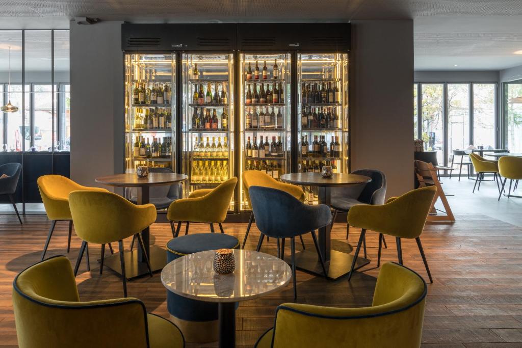 伊兰茨伊甸餐厅酒店的餐厅设有桌椅和酒瓶架