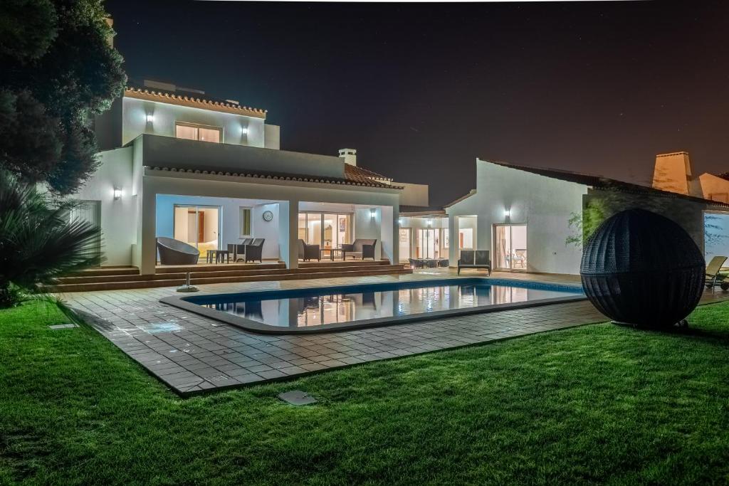 普拉亚德尔瑞伊Deslumbrante V6的夜间带游泳池的别墅