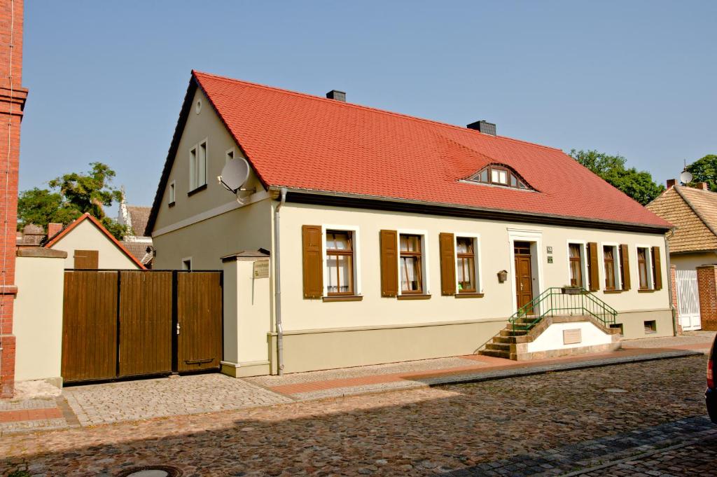 奥拉宁鲍姆Ferienwohnung Matthisson的一间白色的小房子,有红色的屋顶