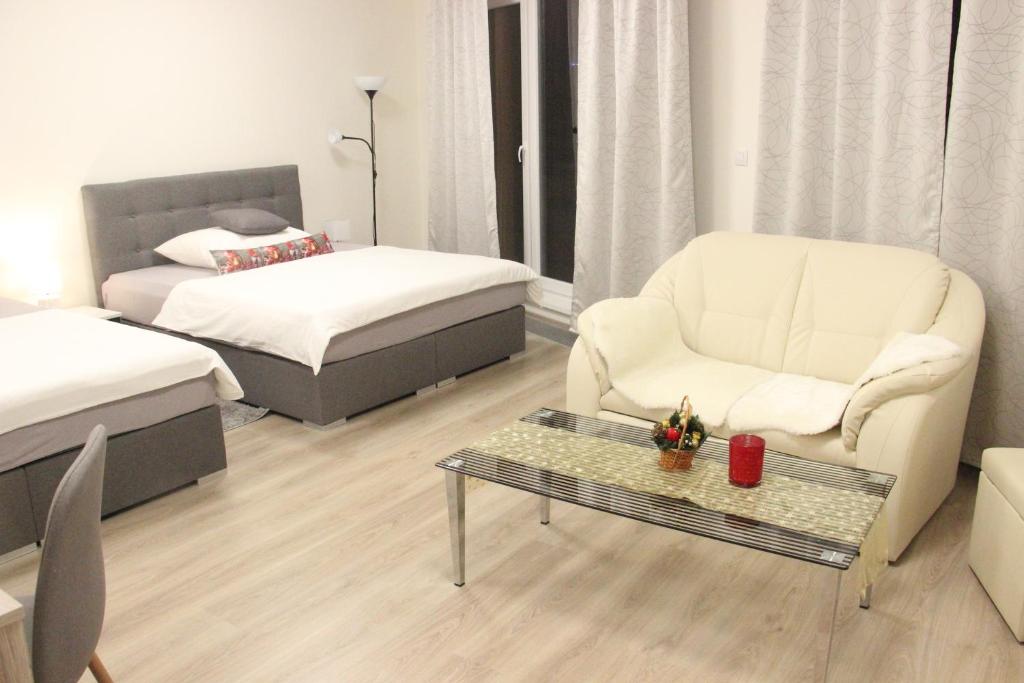 布拉格Element Prag Airport Apartment的客厅配有床、椅子和茶几
