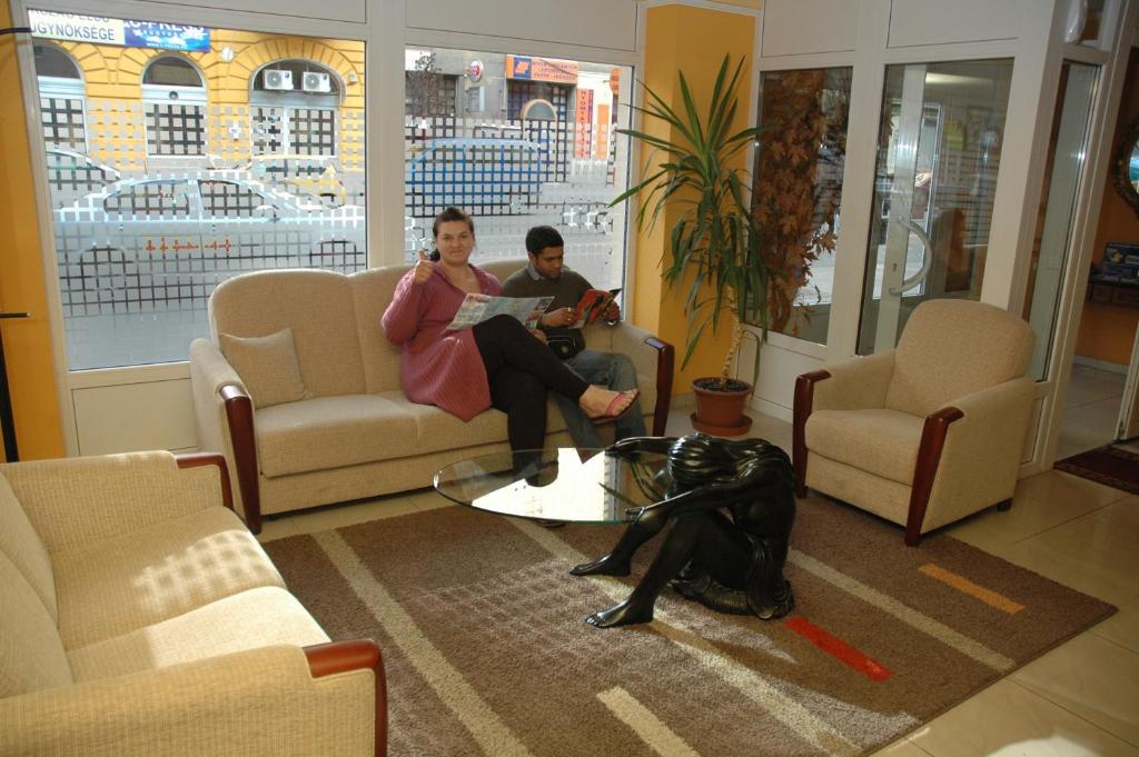 布达佩斯大西洋酒店的两人坐在客厅的沙发上,带一只狗