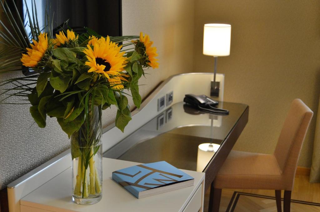 那不勒斯艾瑟达帕拉佐酒店的花瓶里满是向日葵坐在桌子上