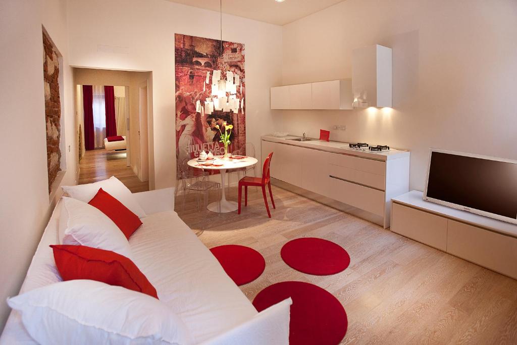 维罗纳维罗纳真意酒店的客厅配有白色沙发和红色地毯。
