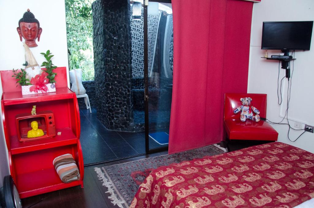 麦德林The Secret Buddha的一间卧室配有一张红色的床和淋浴